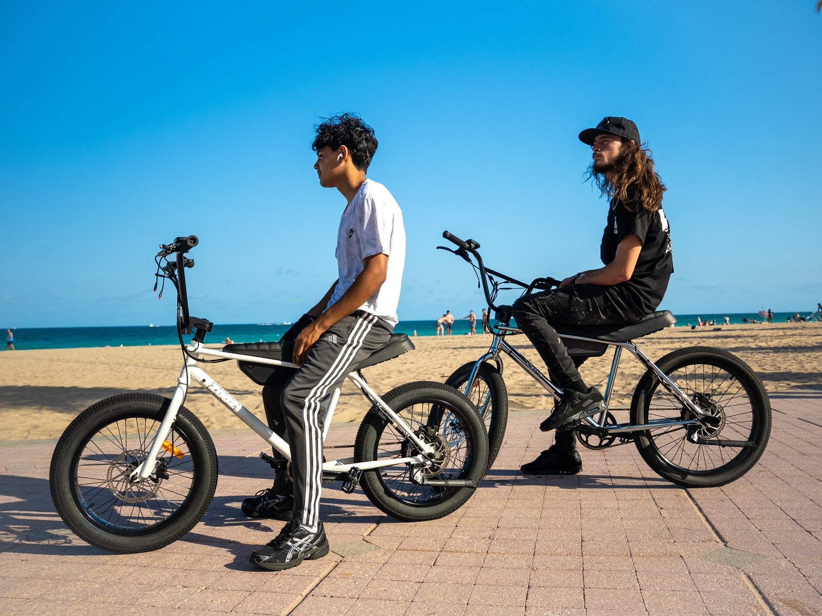 A ZOOZ rider holding a wheelie across an empty lot at golden hour